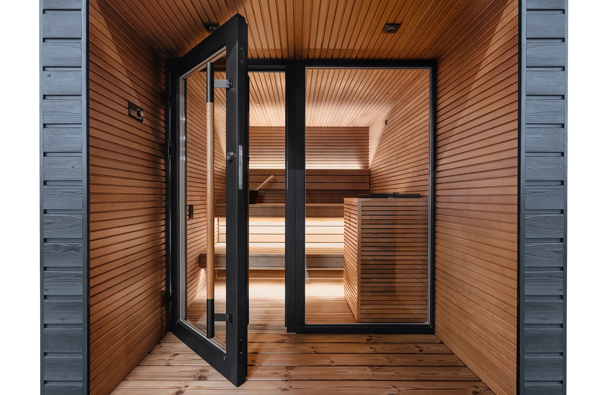 Stylishly designed outdoor sauna with all-glass doors for a luxurious family spa experience